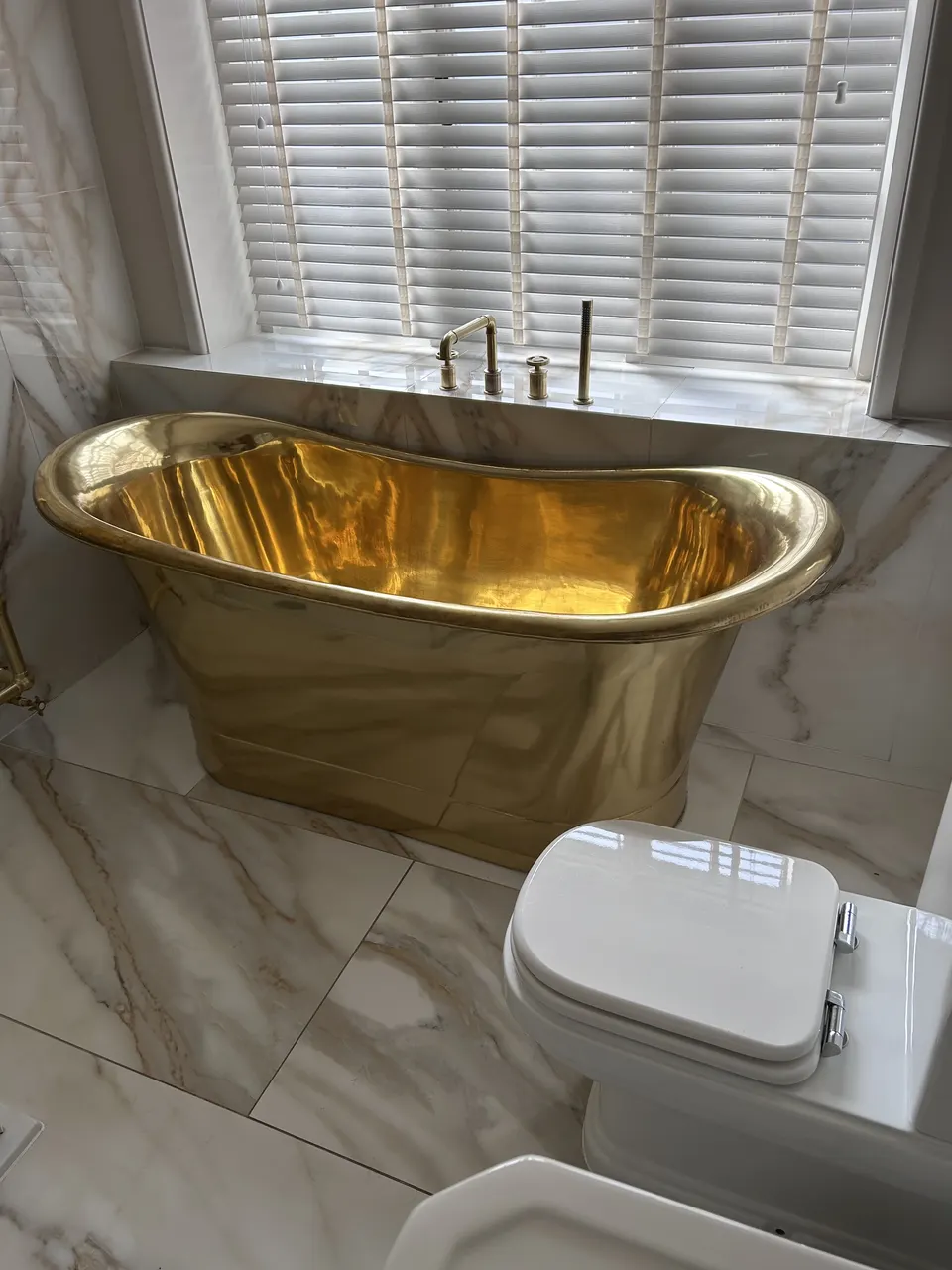 Brass bateau bath & marble bathroom
