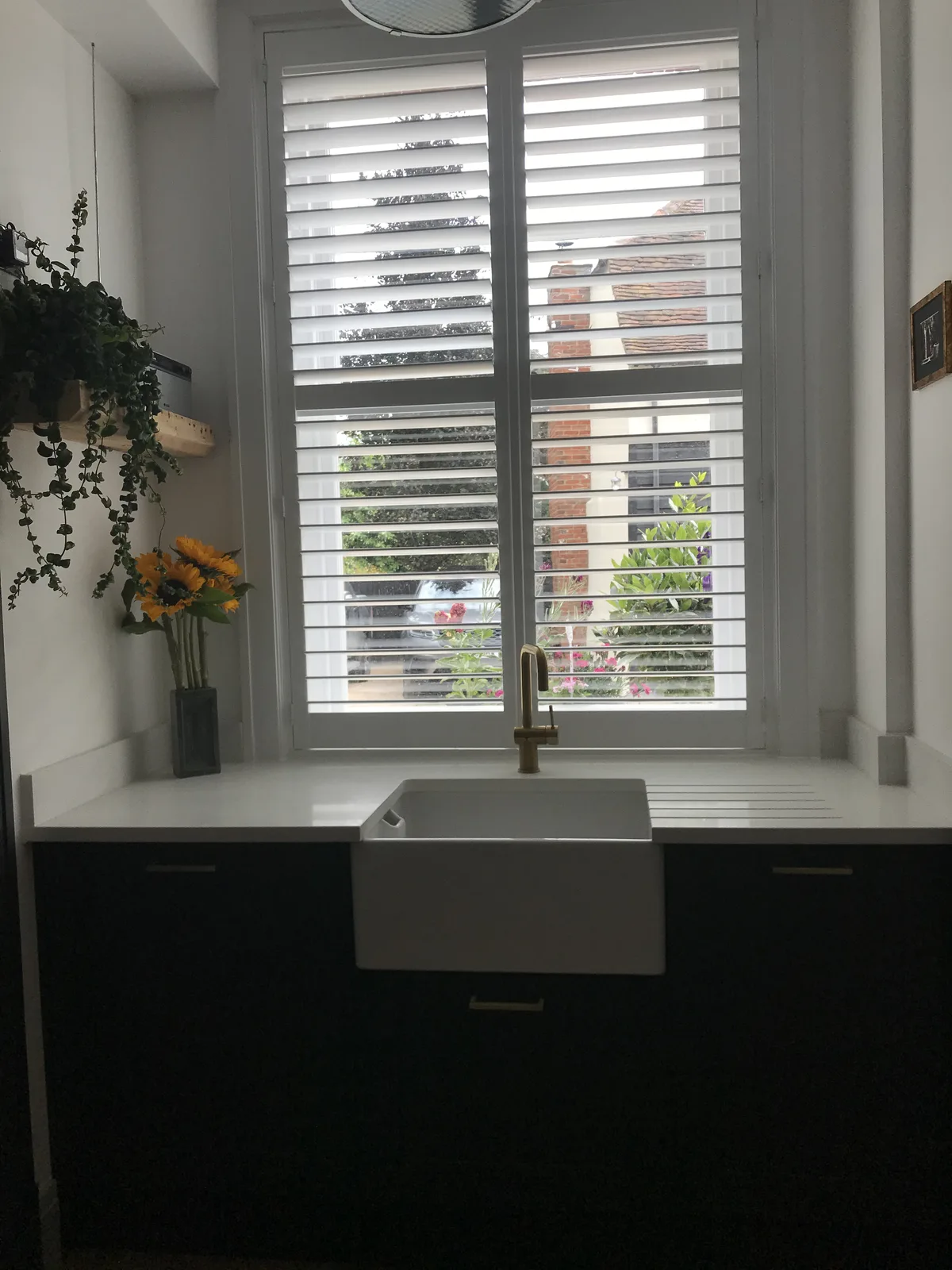 Restored kitchen with Belfast sink and plantation shutters in a listed Essex home