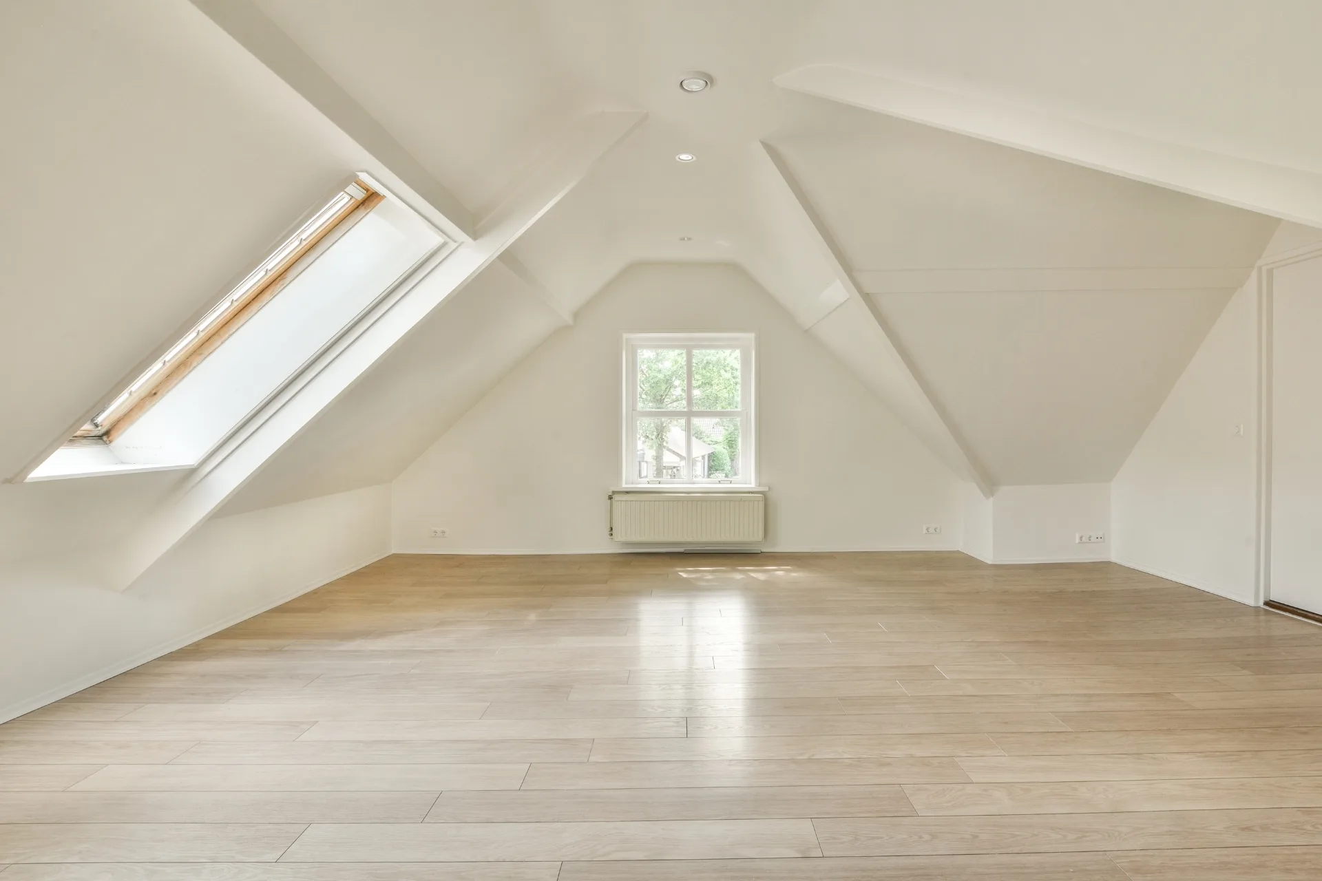 Bright finished loft conversion with skylight and dormer window by Claremont Build & Co